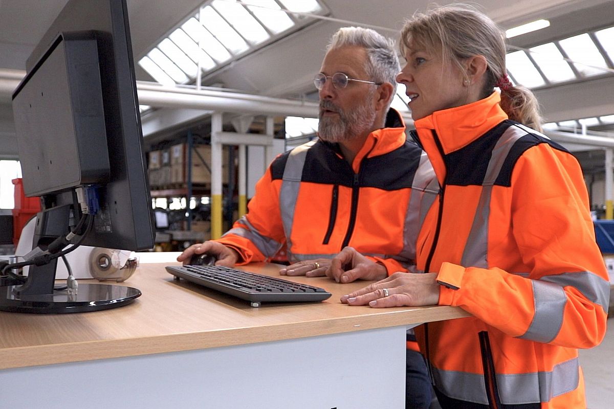 Alarm & Sicherheit Headerbild mit zwei Menschen in Warnkleidung vor Bildschirm