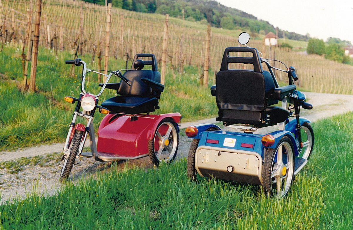Links ein Classic von vorne in rot und rechts nebendran von hinten ein blauen Classic